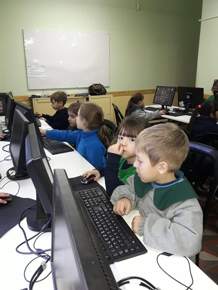 Niñas y niños utilizando computadoras en clase