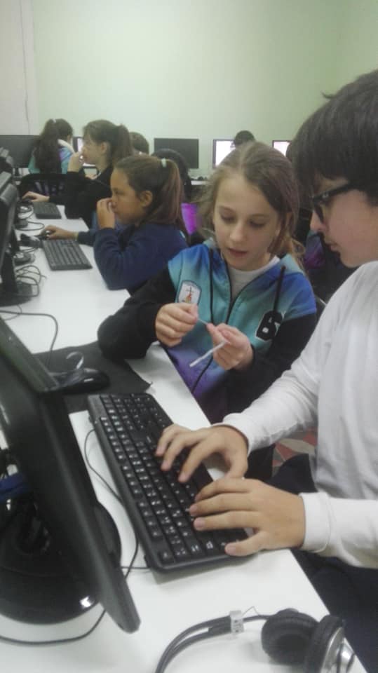 Estudiantes trabajando con computadoras en el aula