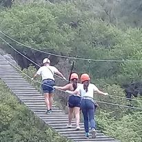 Estudiantes cruzando un puente colgante