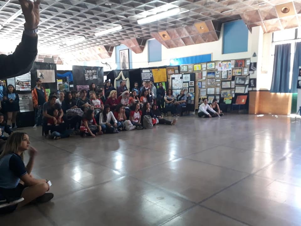 Personas reunidas en el salón durante una muestra escolar